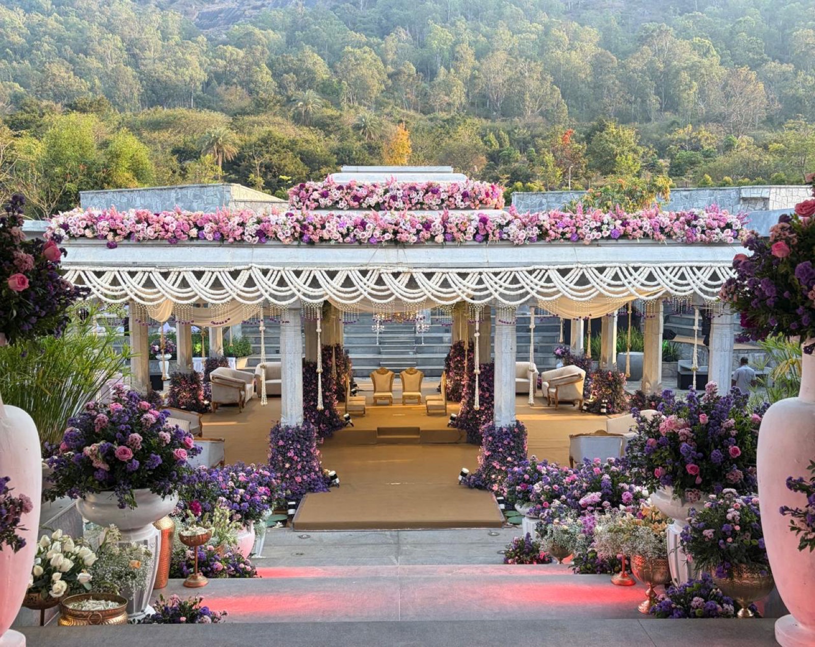 White pavilion mandap with lavender and rose floral urns lining the ceremony steps — Panigrahana decor