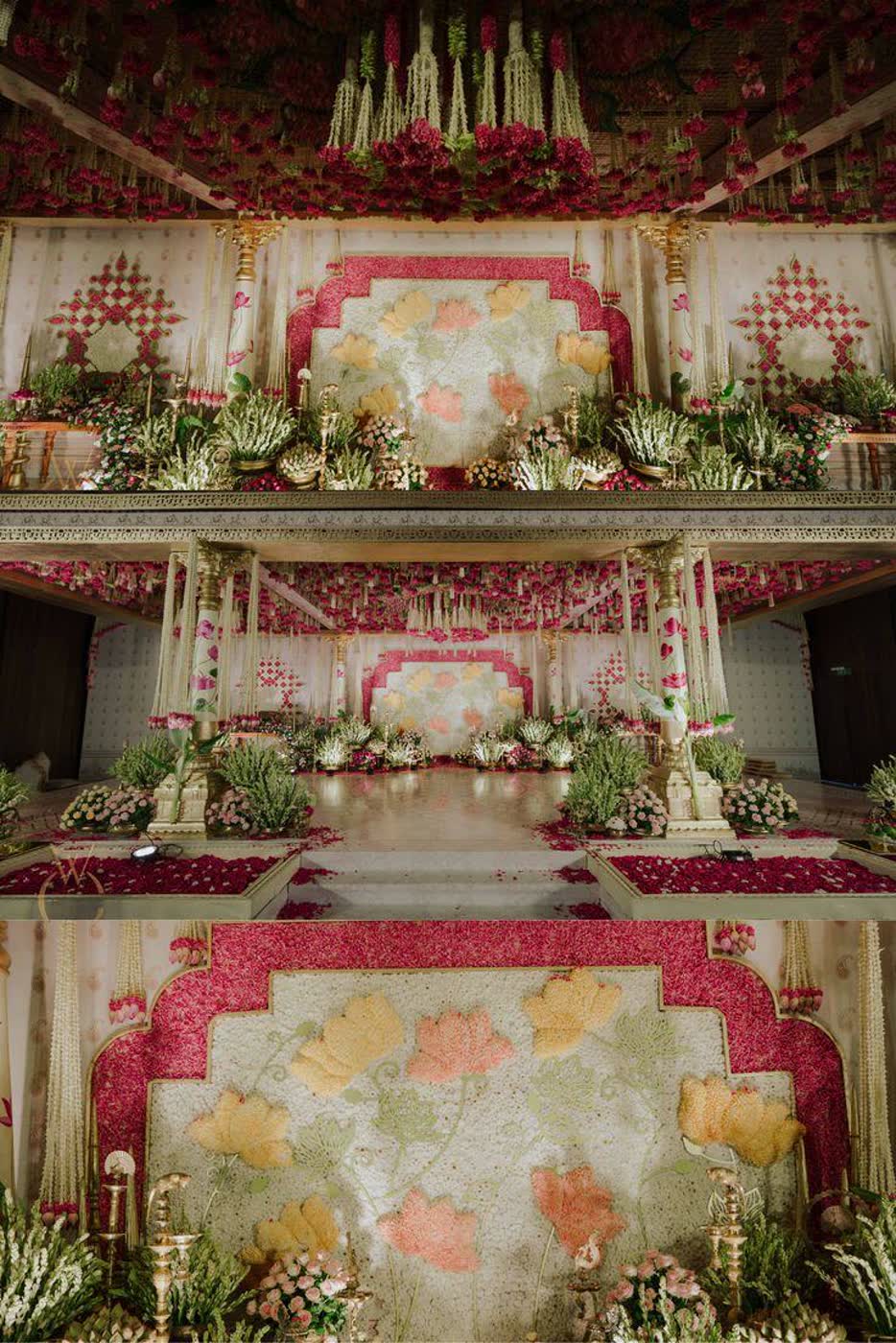 Traditional red and gold mandap backdrop with hand-laid lotus motifs in cream and saffron over a crimson floral ground