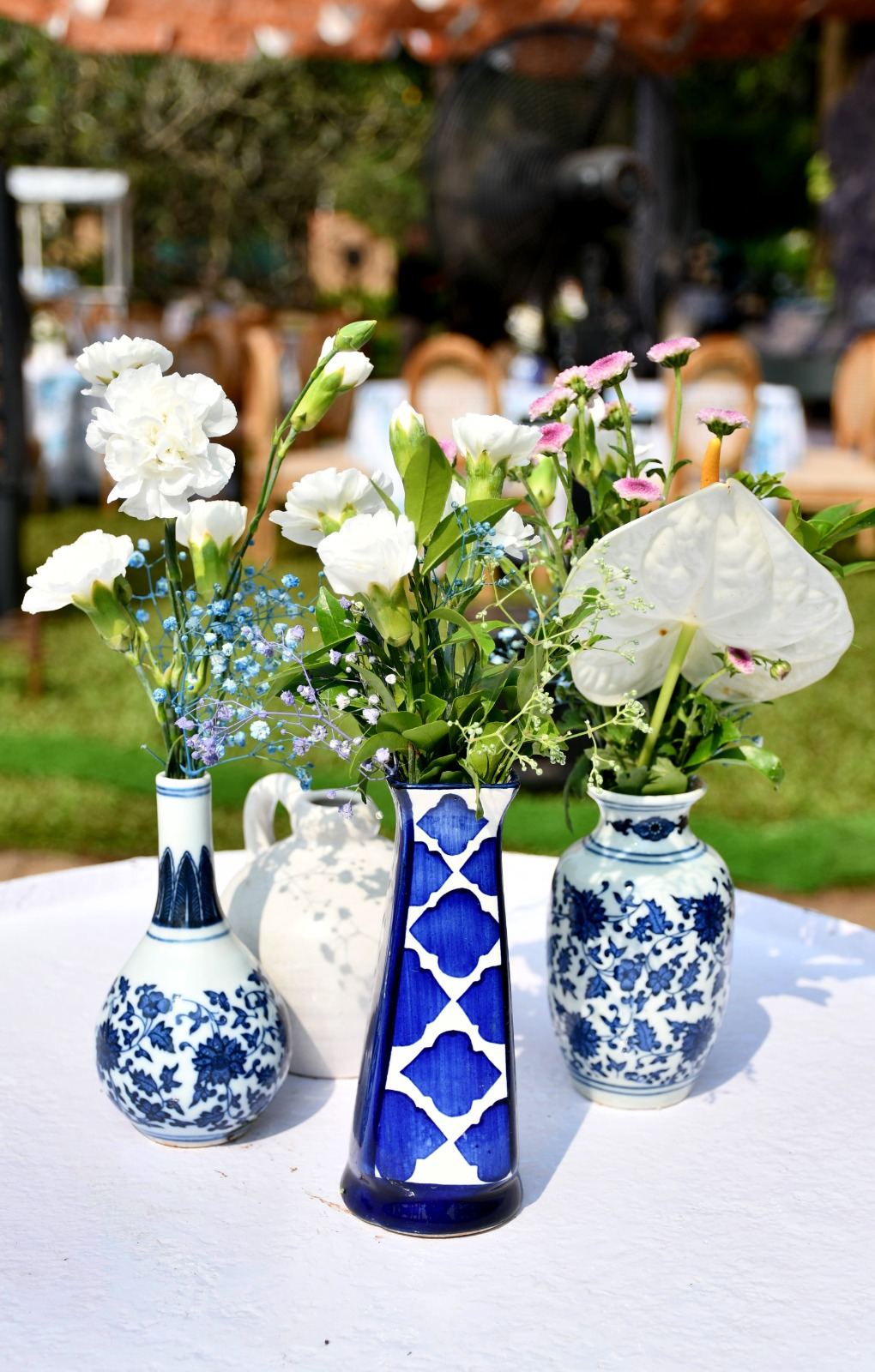 Blue and white porcelain vases holding fresh white florals in sunlight