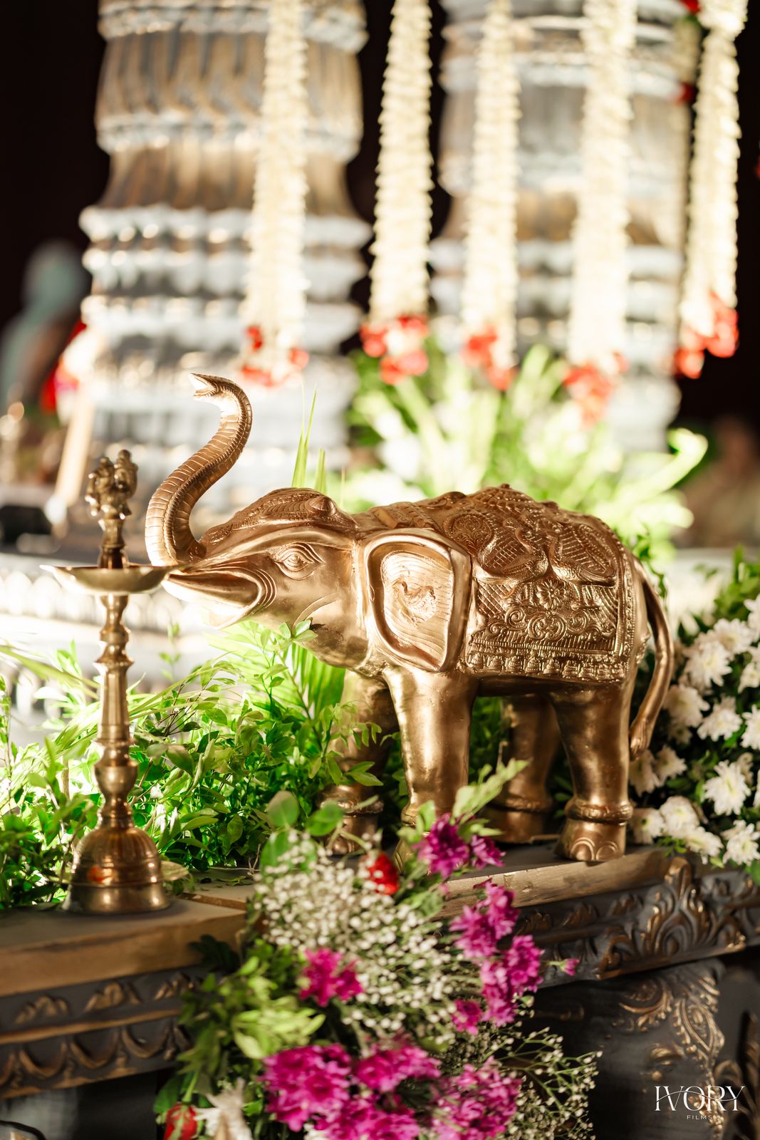 Brass elephant figure styled with purple orchids and fresh greenery