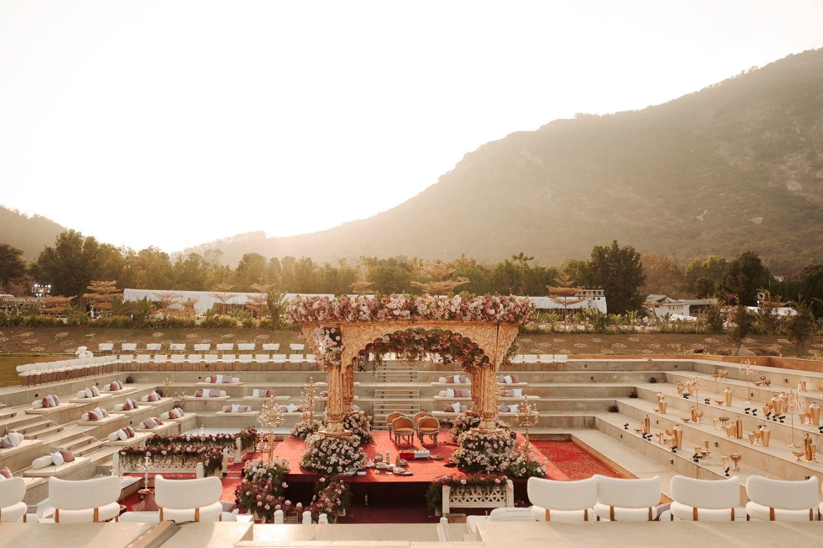 Wide view of a hillside wedding amphitheatre with mandap at first light