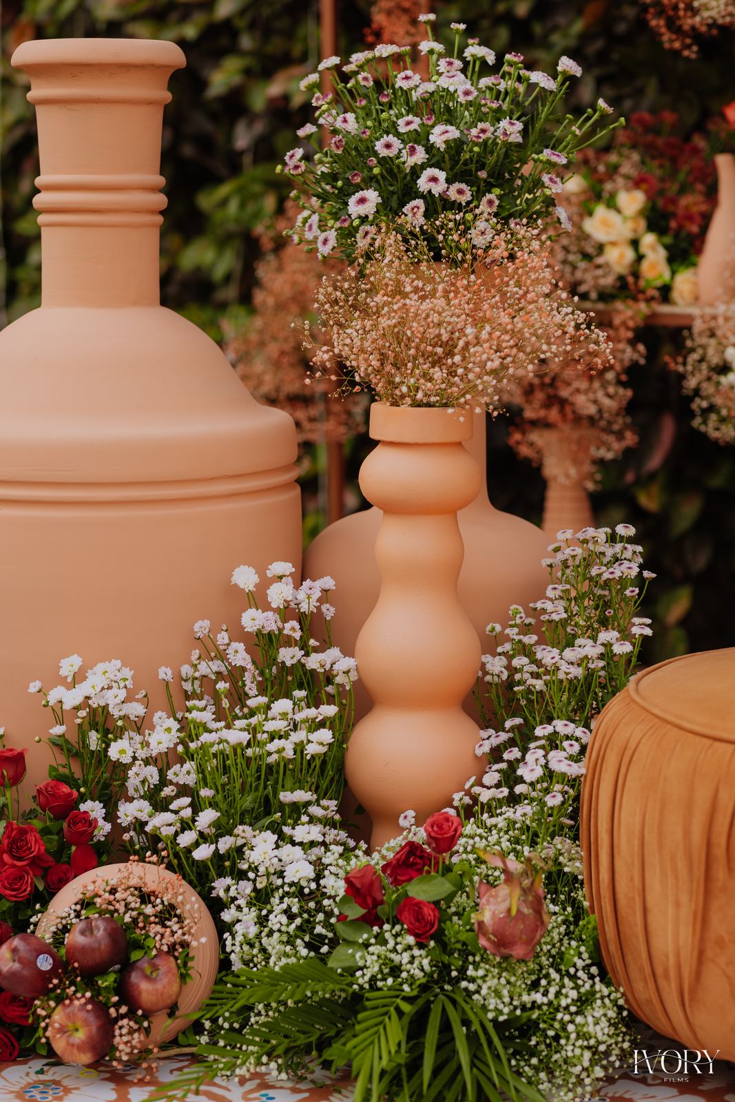 Terracotta urns with baby's breath and rose clusters on patterned flooring