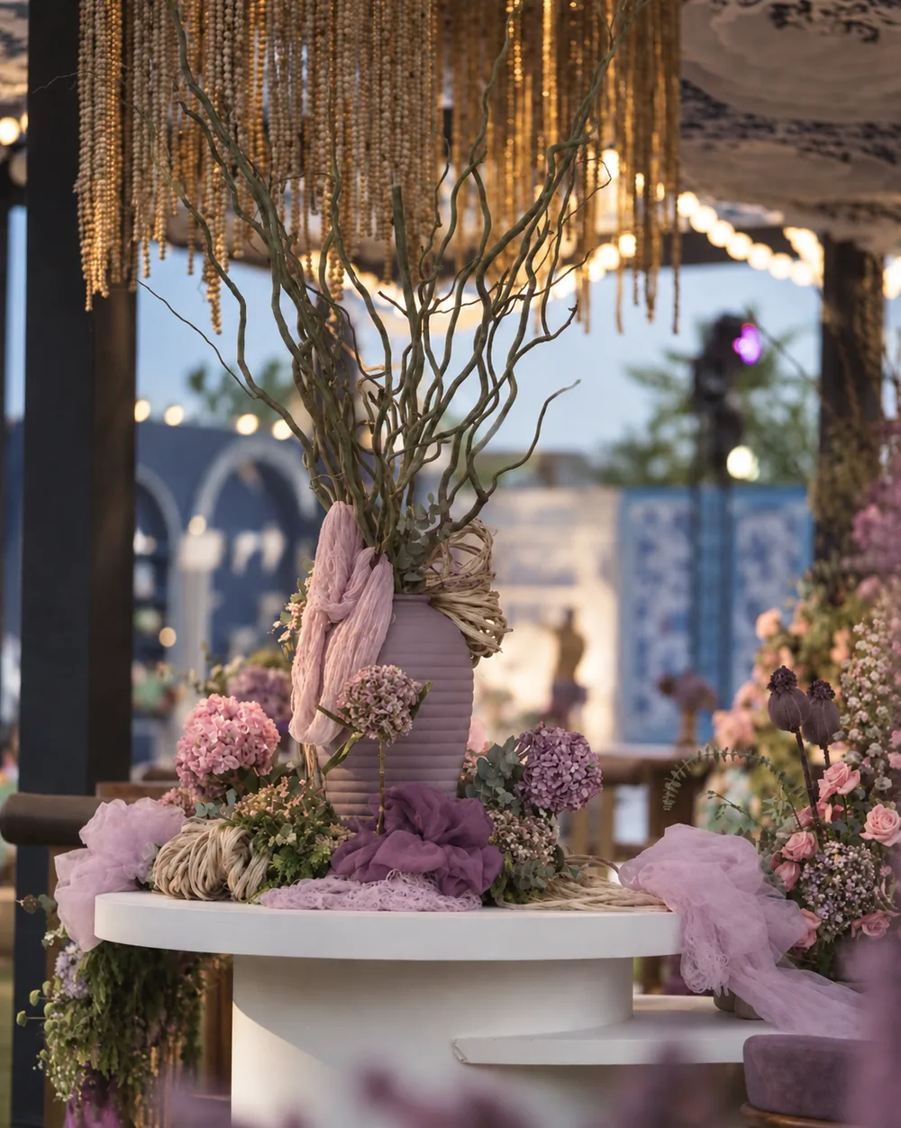 Branch arrangement above a curved white dining table at Amitarasa, Bangalore. Decor execution by Panigrahana Weddings.