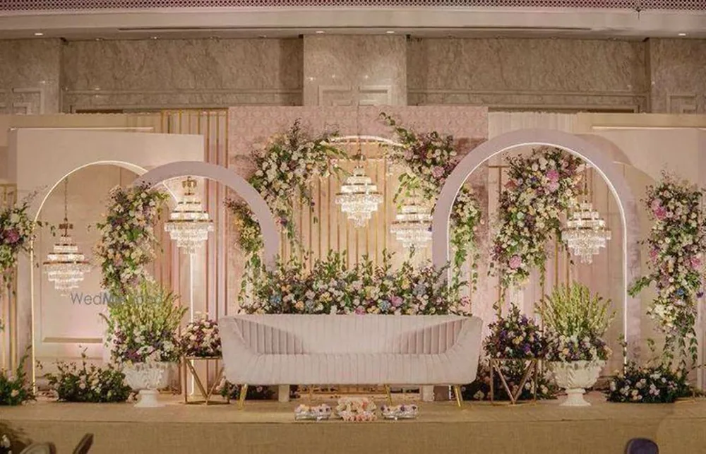 Blush arched reception backdrop with chandeliers — Panigrahana decor portfolio