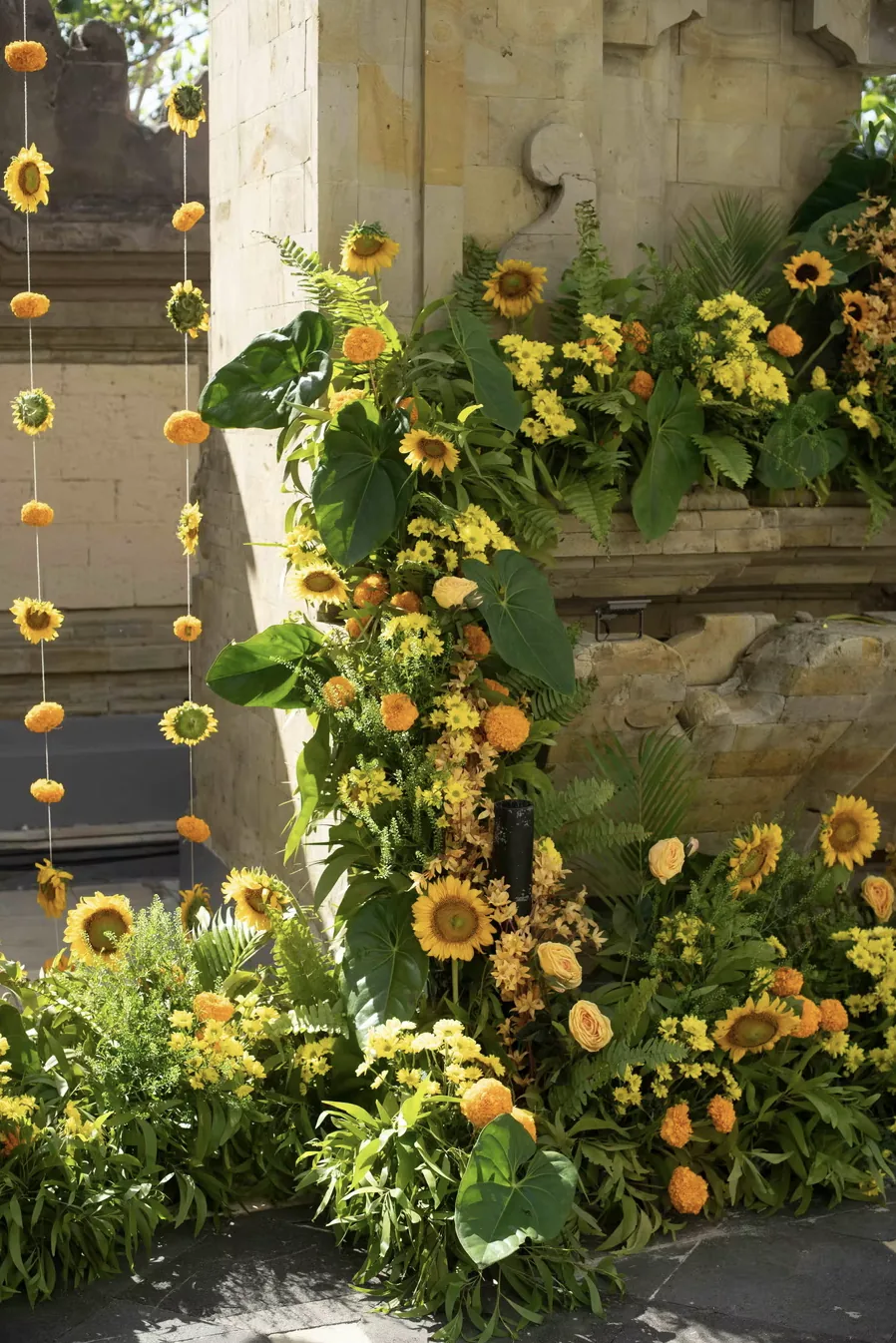 Sunflowers against a carved stone wall at Hilton Bali — Panigrahana decor portfolio