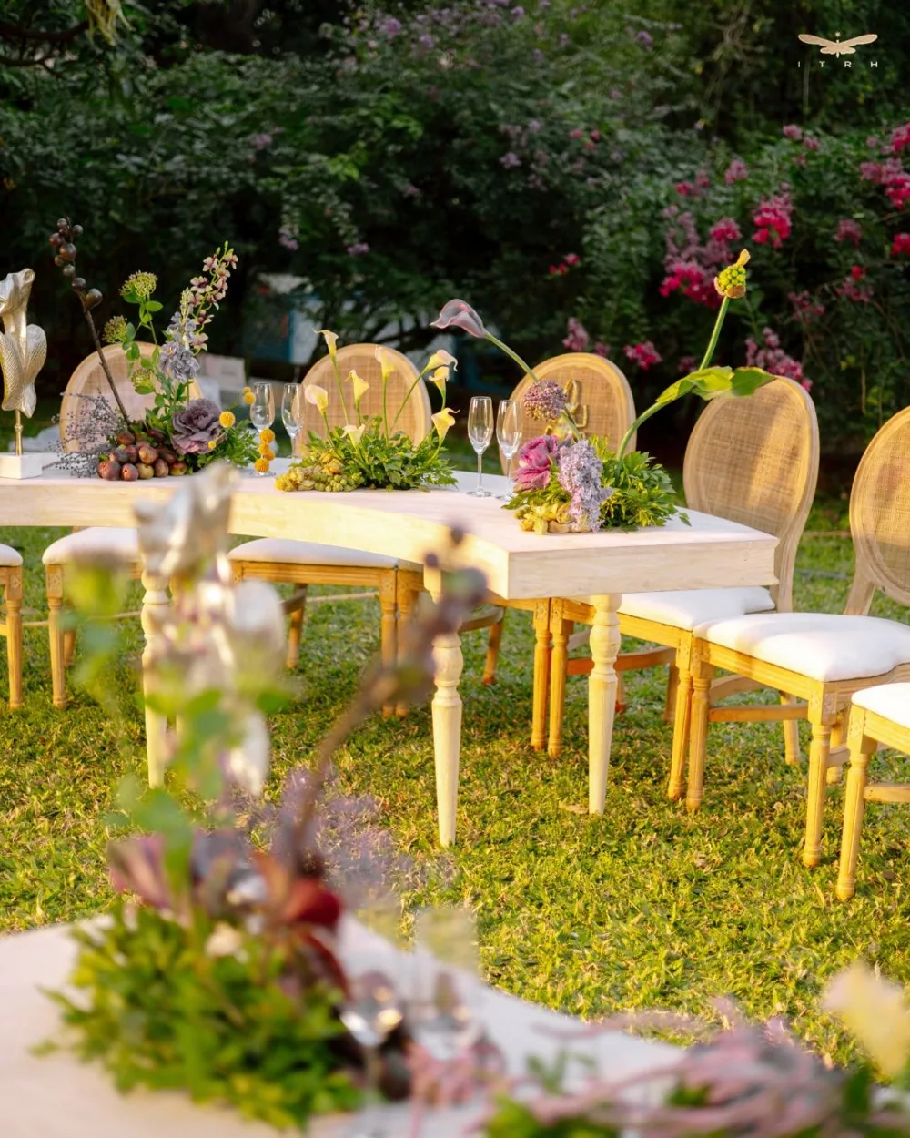 Garden tables with cane chairs and mixed flowers — completed Panigrahana work