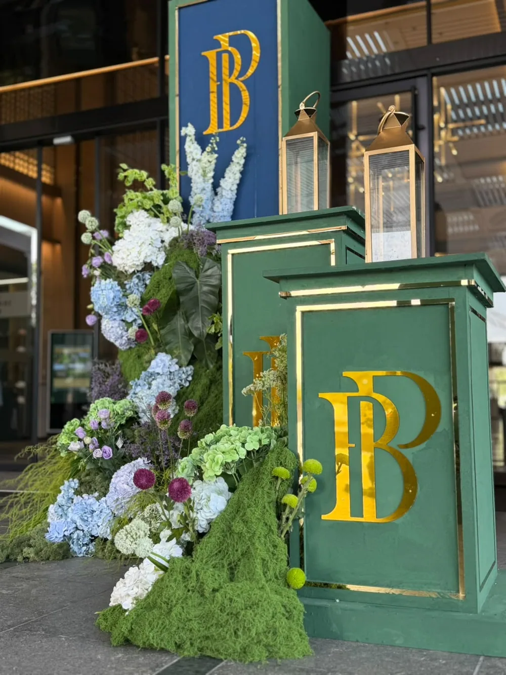 Gold monogram on a green plinth with brass lanterns — Panigrahana decor portfolio