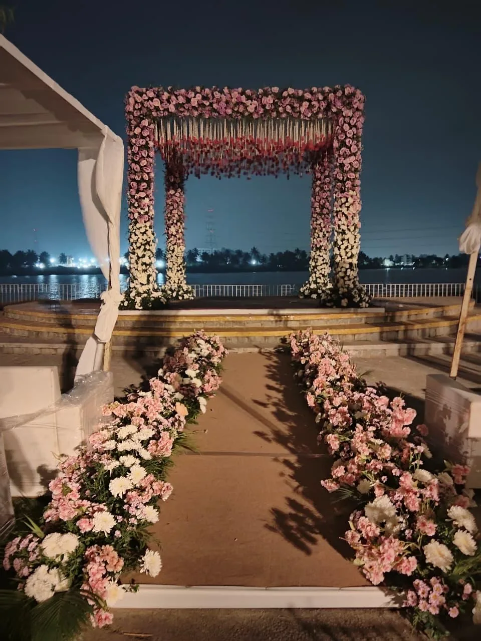 Floral aisle leading to the lakeside mandap at Moongate