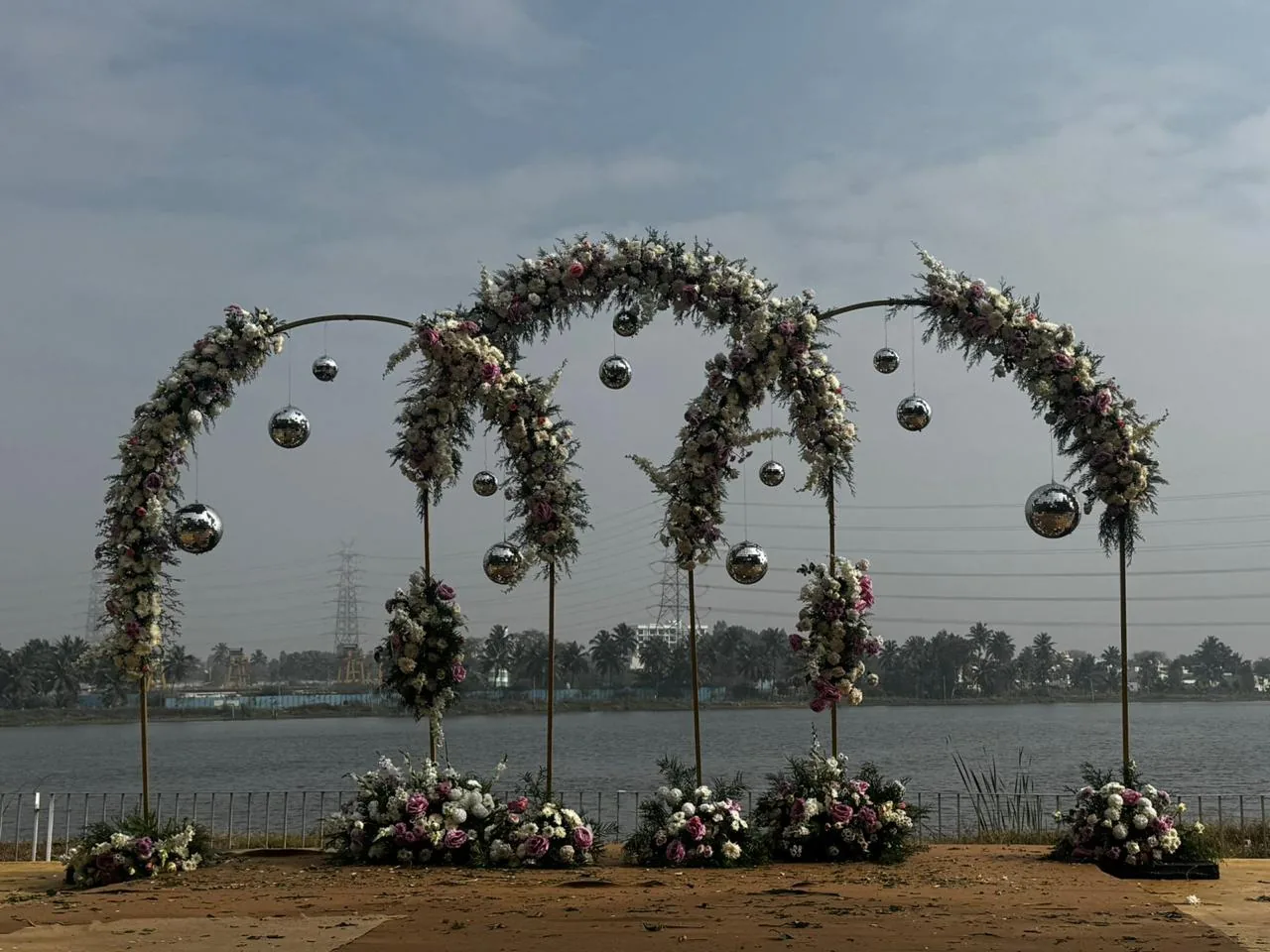 Lakeside floral arches with hanging globes at Moongate