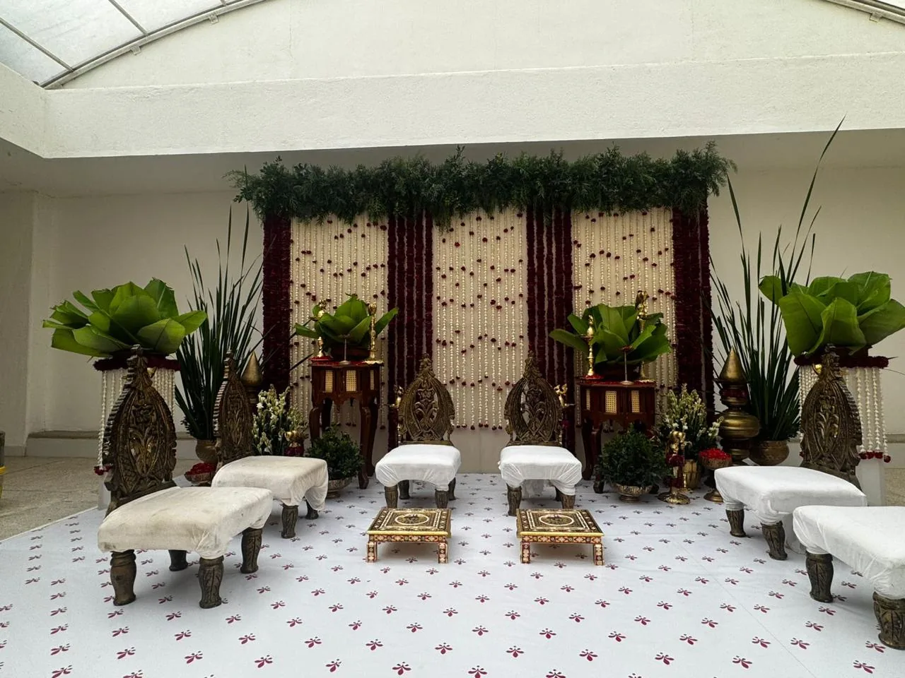 White ceremony seating with banana leaves at Moongate