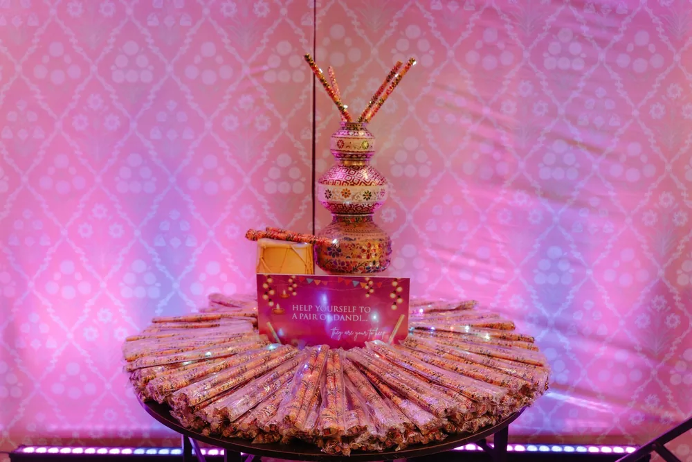 Sangeet dandiya station at Riva Beach Resort, Goa: painted matkis topped with dandiya sticks, a small dhol, a help-yourself sign and a table of wrapped sticks.