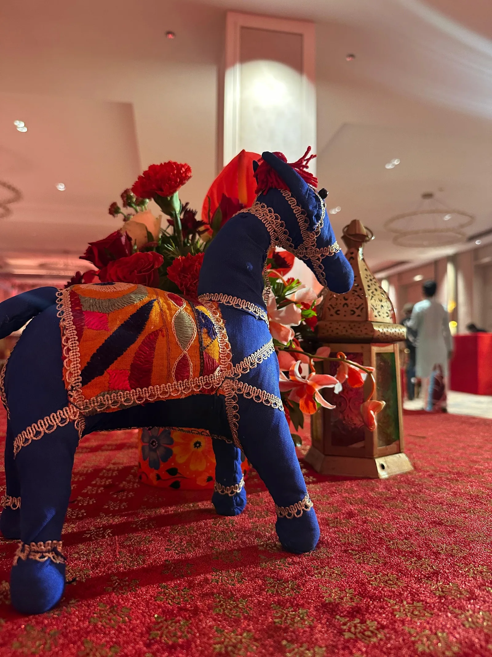 Blue decorative horse and red floral table details at The St. Regis Goa Resort