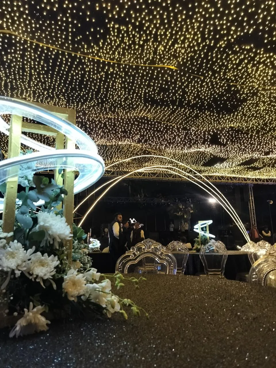 Canopy of warm lights above an illuminated floral installation at The St. Regis Goa Resort