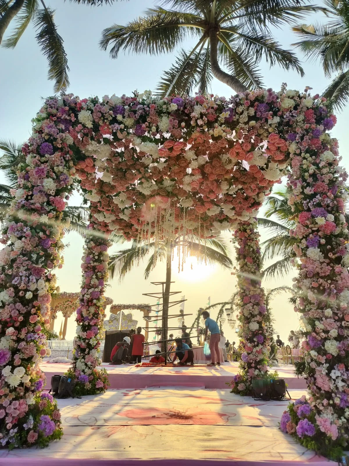 Pink floral arch framing a seaside mandap at The St. Regis Goa Resort