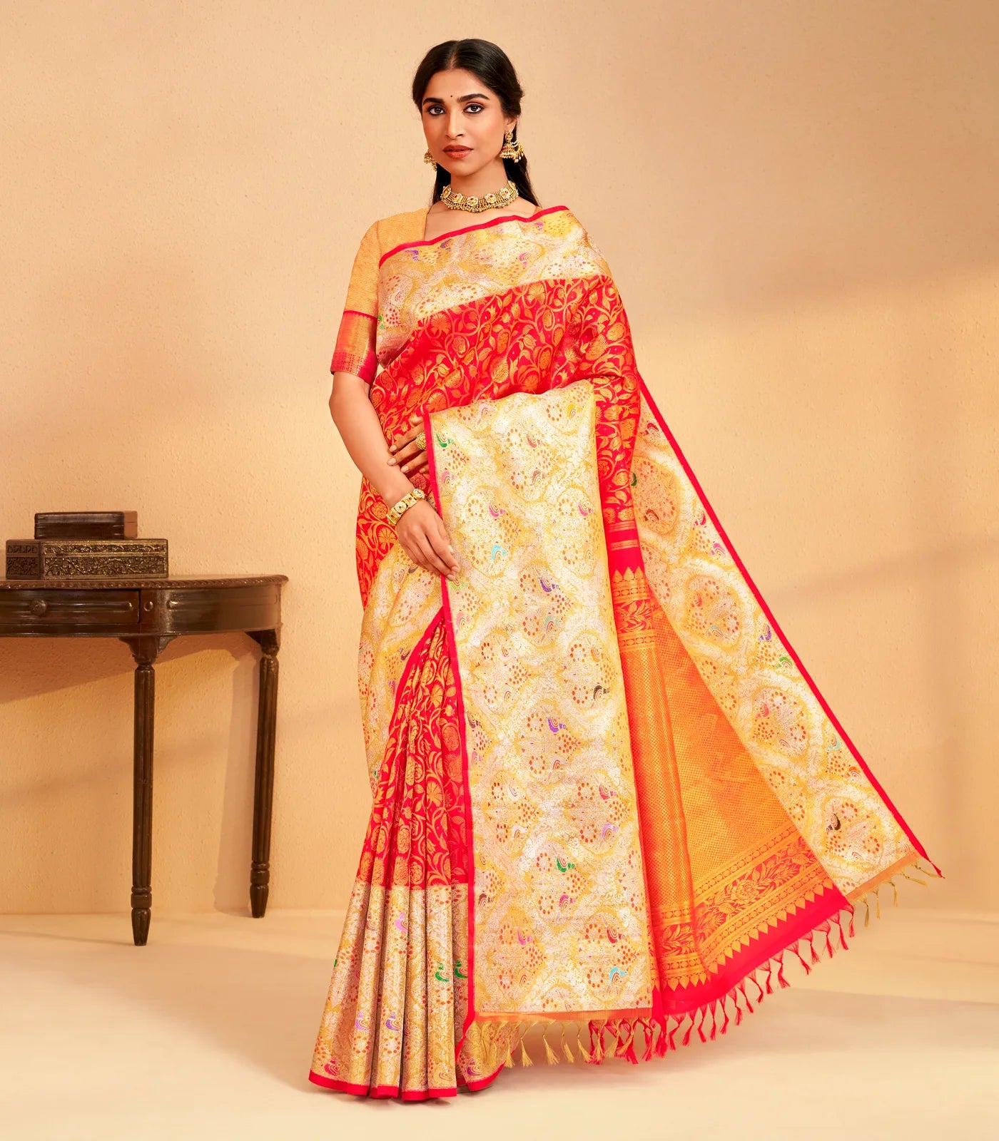 Red and gold Korvai Kanchipuram bridal silk saree with floral motifs, worn by a model