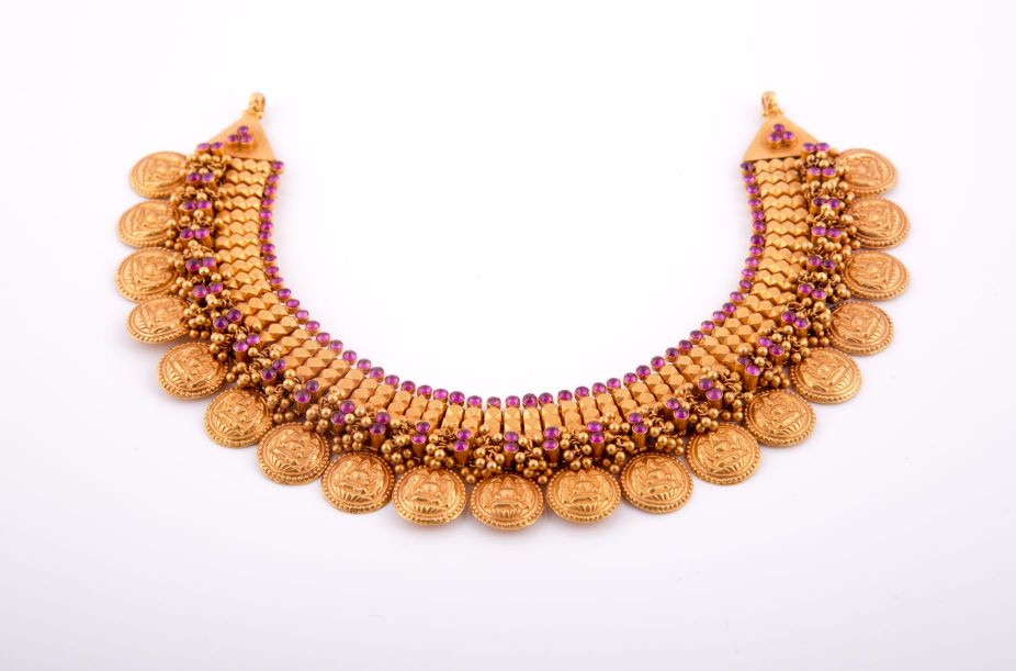 Antique gold necklace with a fringe of embossed coin pendants and pink stones