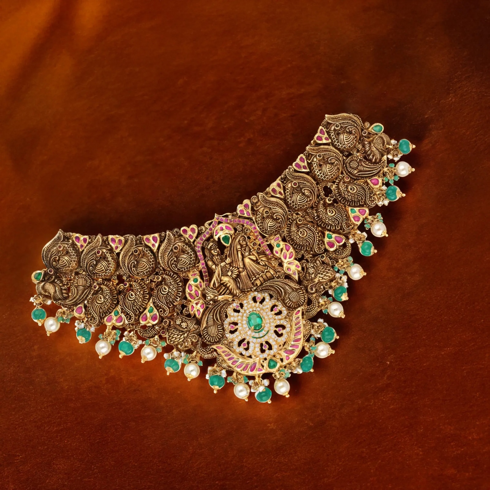 Antique gold temple choker with a deity panel, peacocks, rubies, emeralds and pearl drops
