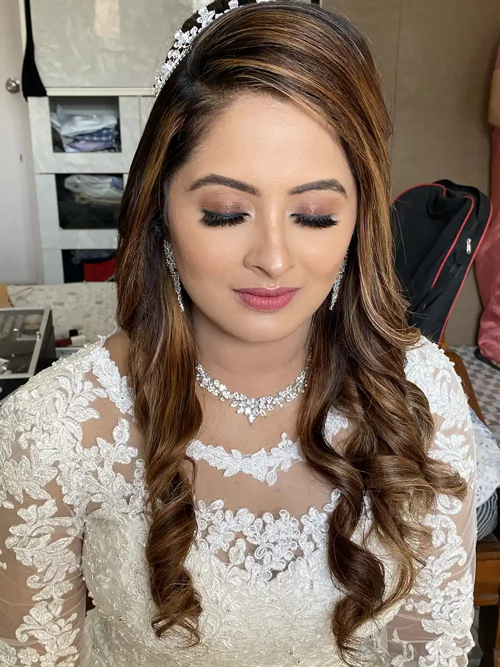 Christian bride with soft brown eye makeup, a pink lip, loose curls, a tiara and a white lace gown