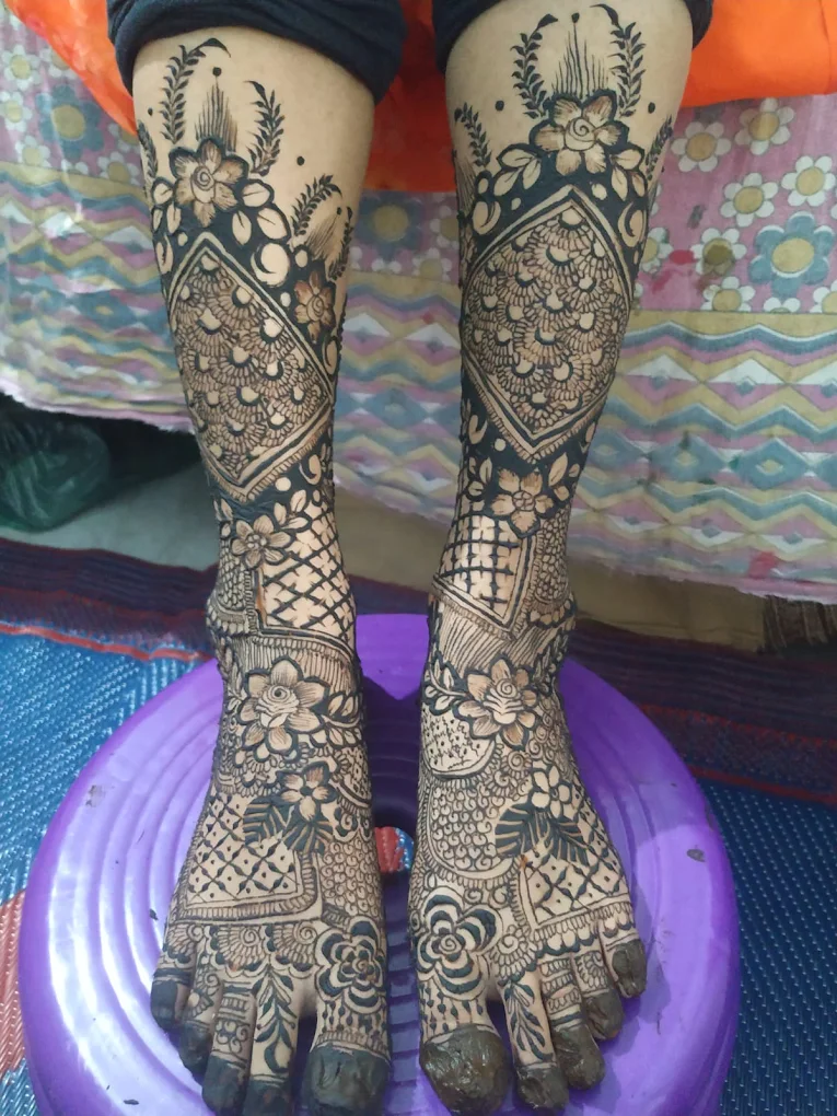 Fresh bridal mehendi on both feet and legs, from the toes to mid-calf, with floral panels and lattice