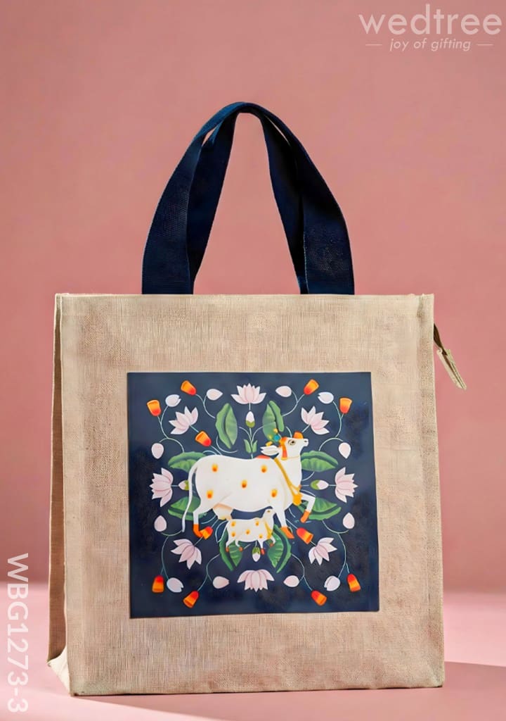 Cloth thamboolam bag with navy handles and a Pichwai cow-and-lotus print panel