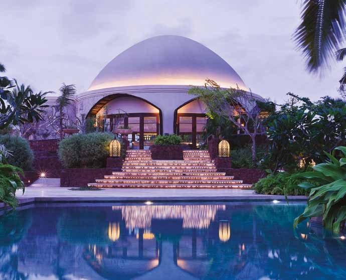The domed pavilion above the pool at Taj Bekal lit at dusk, lanterns set along the wide steps down to the water