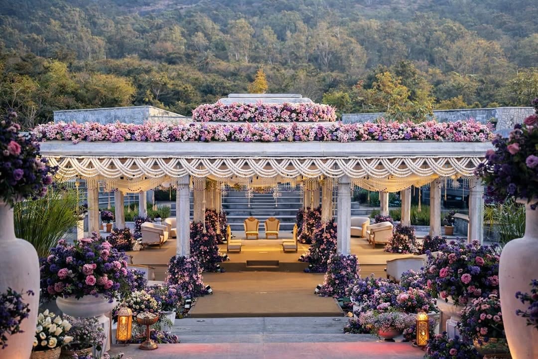 Pink and purple rose mandap at golden hour with rose-filled urns and gold ceremony seating at Amita Rasa, designed by Panigrahana