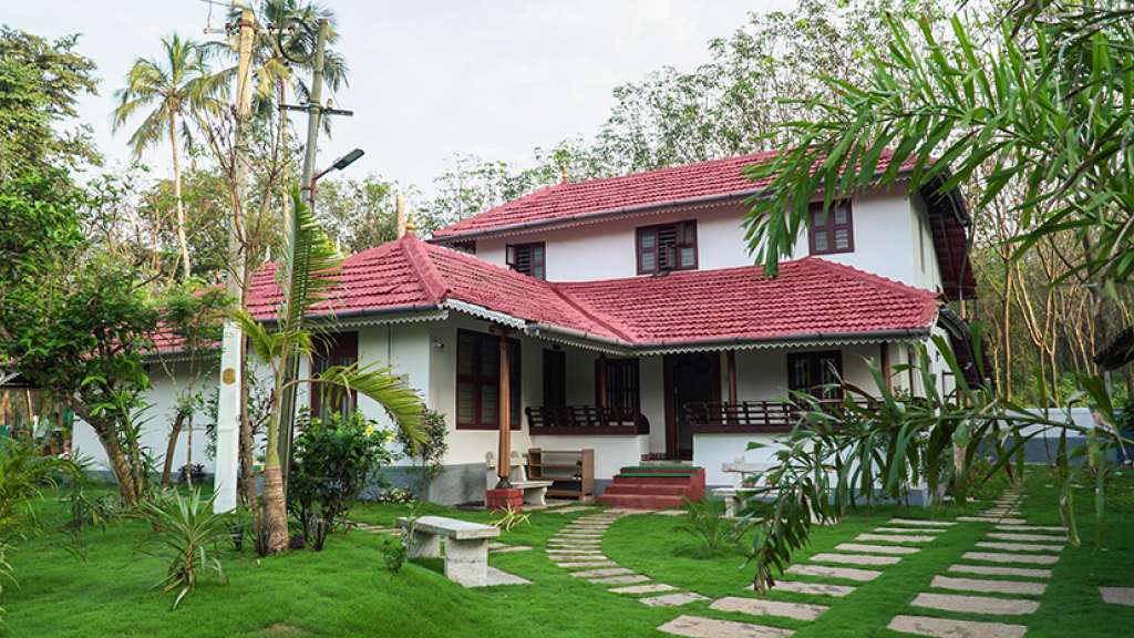 Traditional tiled-roof house and garden at Anamala Serenity Homestays in Thiruvilwamala
