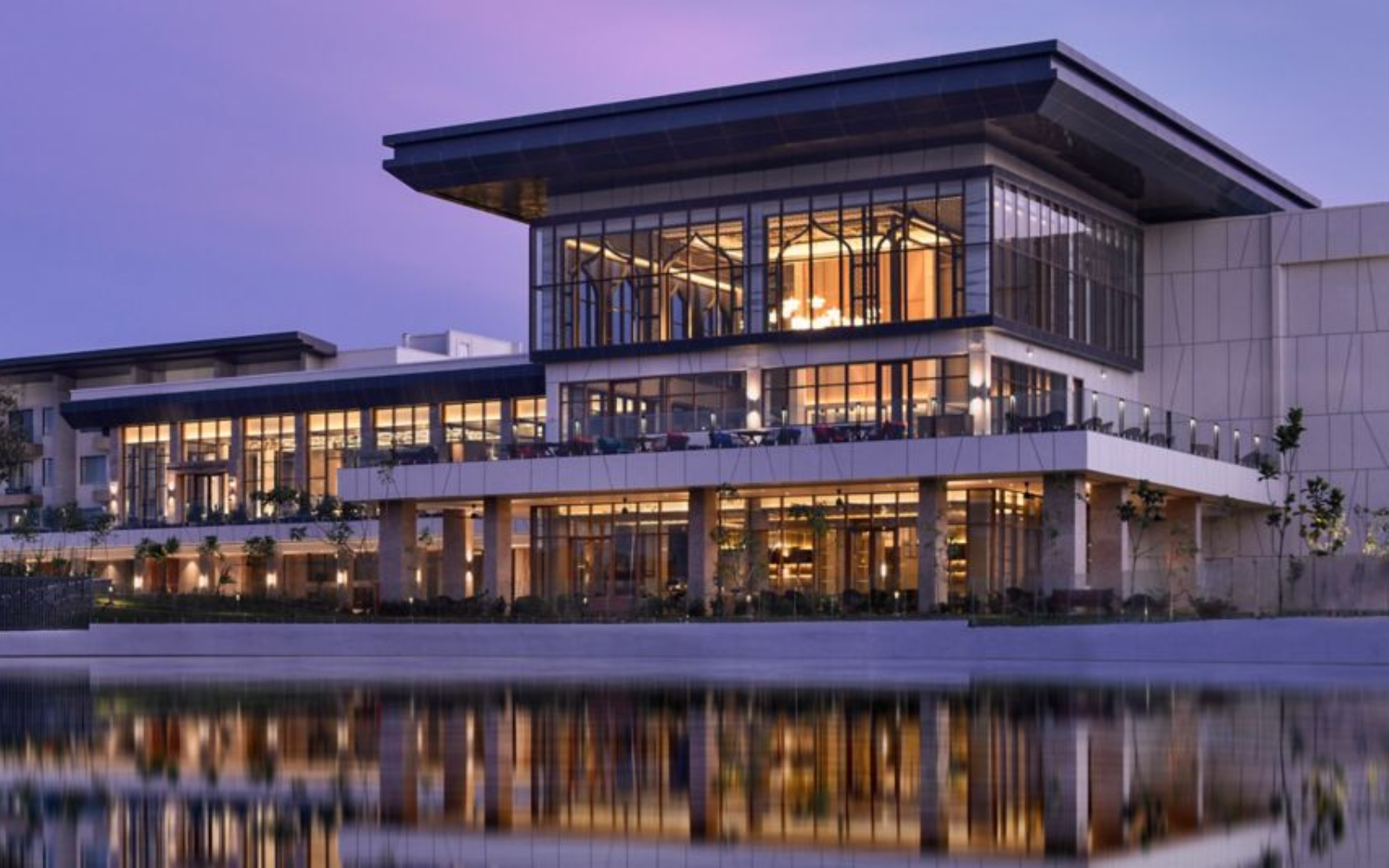 Lakeside facade of JW Marriott Bengaluru Prestige Golfshire Resort & Spa at dusk