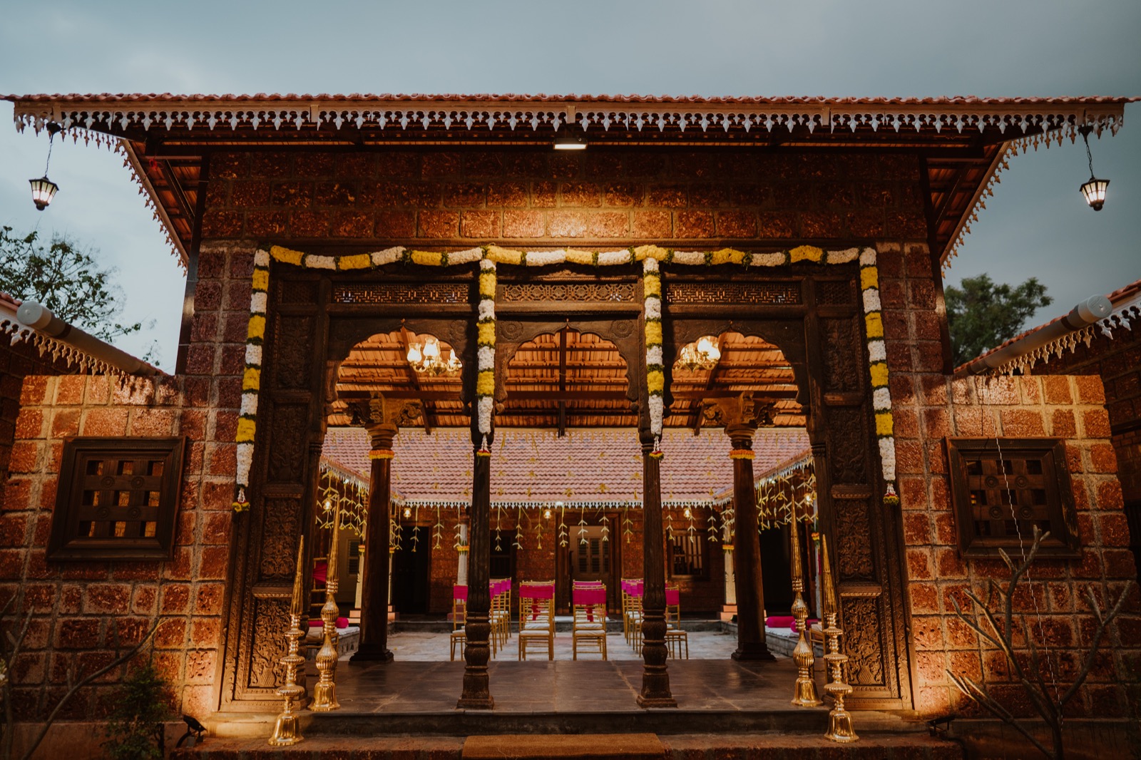 Carved timber gateway and heritage courtyard at The Tharavadu Mane, Bengaluru
