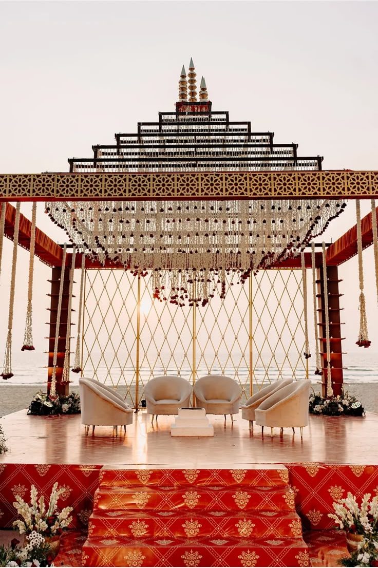 Traditional South Indian mandap with a tiered gopuram silhouette built on the sand at The St. Regis Goa, the Arabian Sea behind it at sunset, designed by Panigrahana