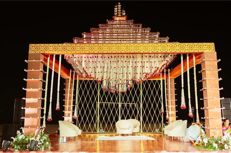 The same gopuram mandap lit at night with jasmine and rose garland curtains