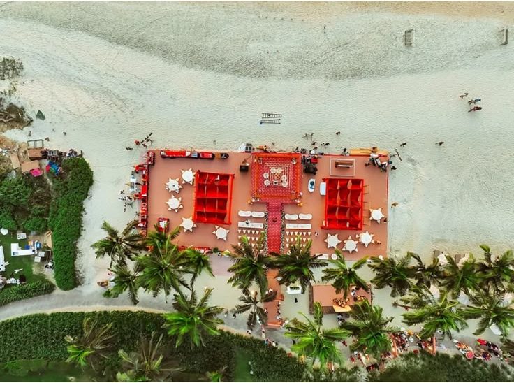 Aerial view of the red beach mandap setup and guest seating on the sand at The St. Regis Goa