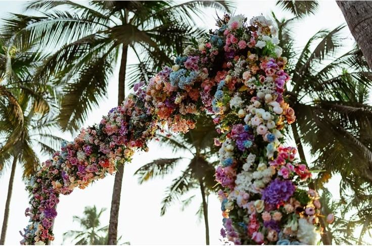 Pastel floral arch under coconut palms at the Western ceremony in Goa