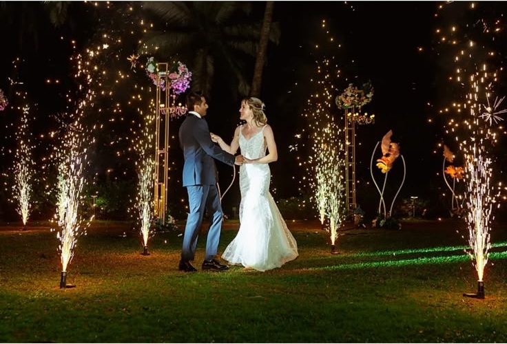 The couple's first dance on the lawn framed by sparkler fountains at night