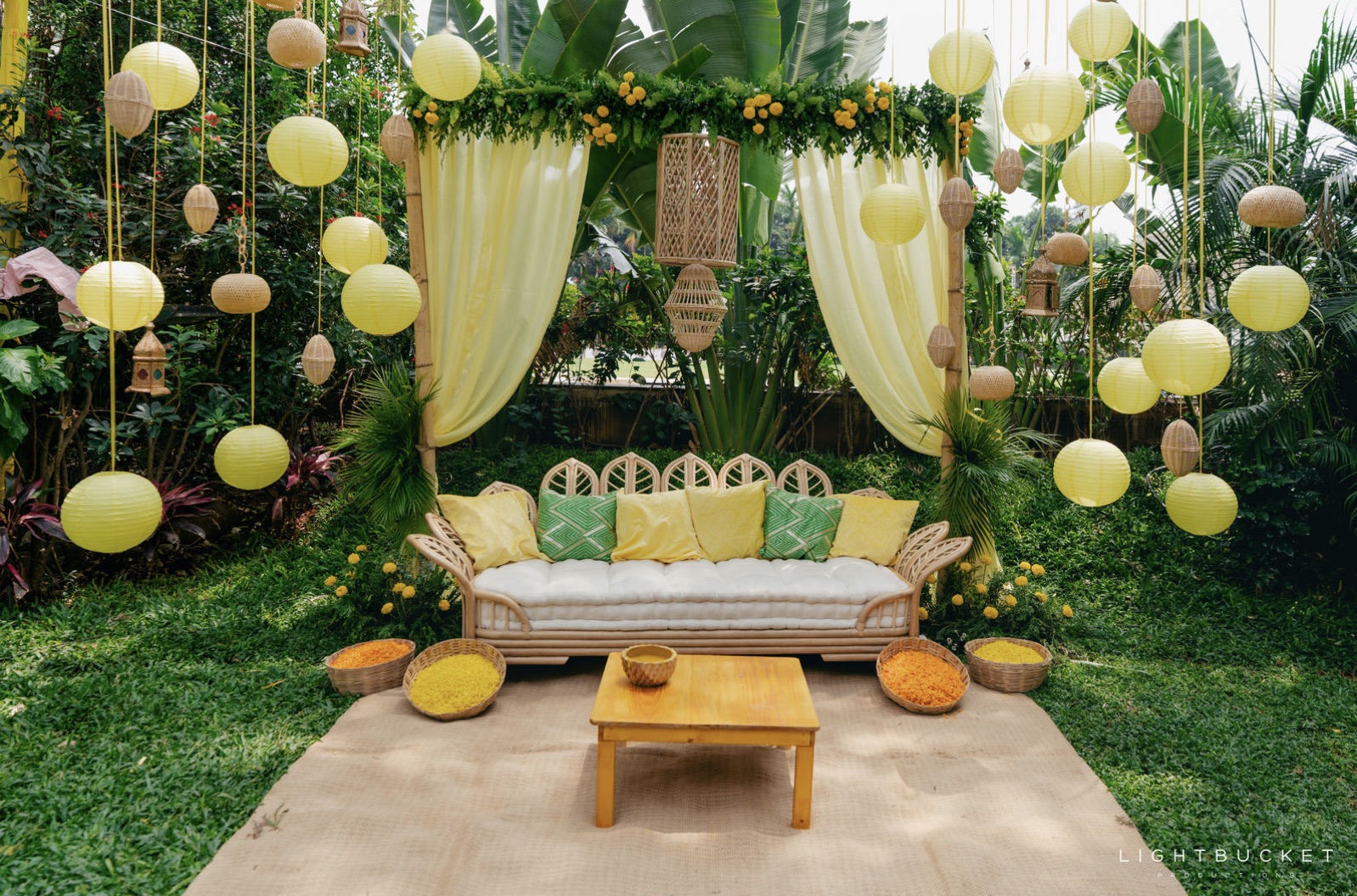 Garden lounge area at Nature Knots with cane seating and hanging paper lanterns