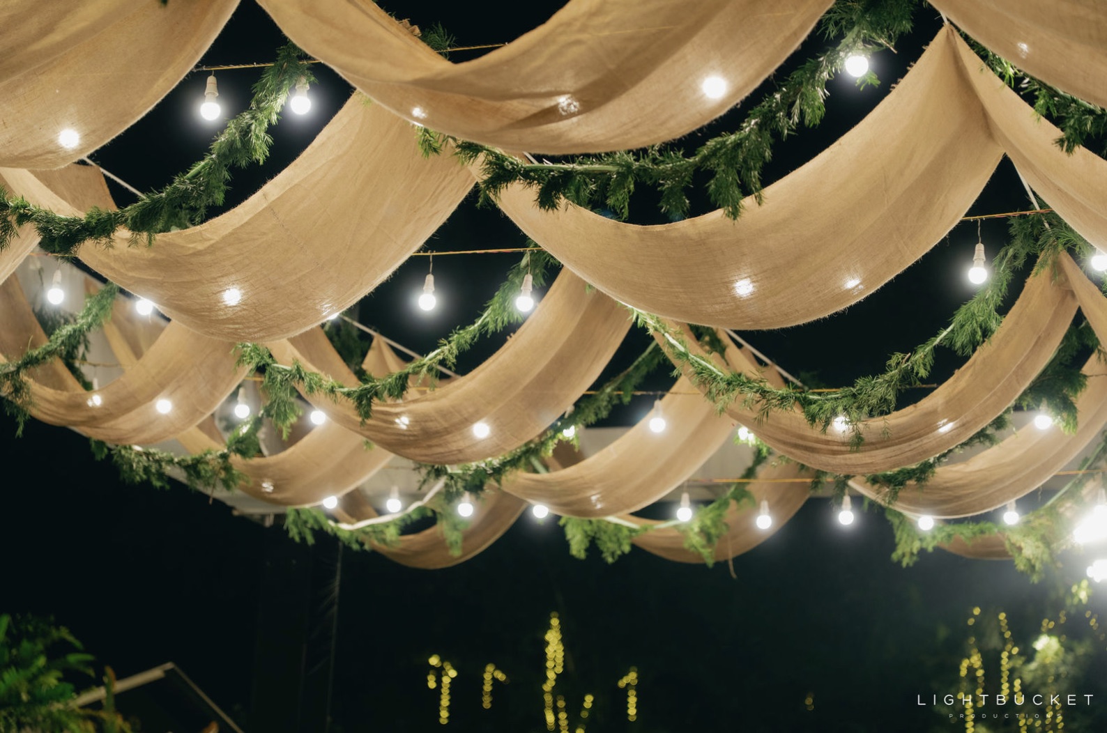 Jute fabric canopy swags with fern garlands and filament bulbs at night at a Bangalore wedding