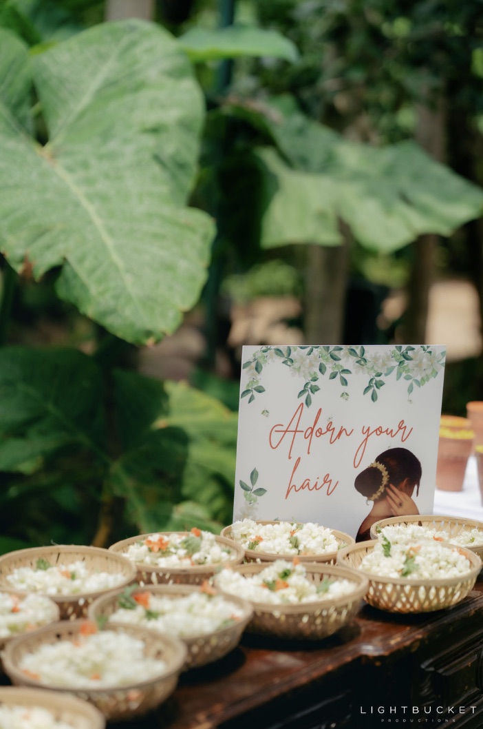 Gajra bar with baskets of jasmine gajras and an Adorn Your Hair sign at Nature Knots Bangalore