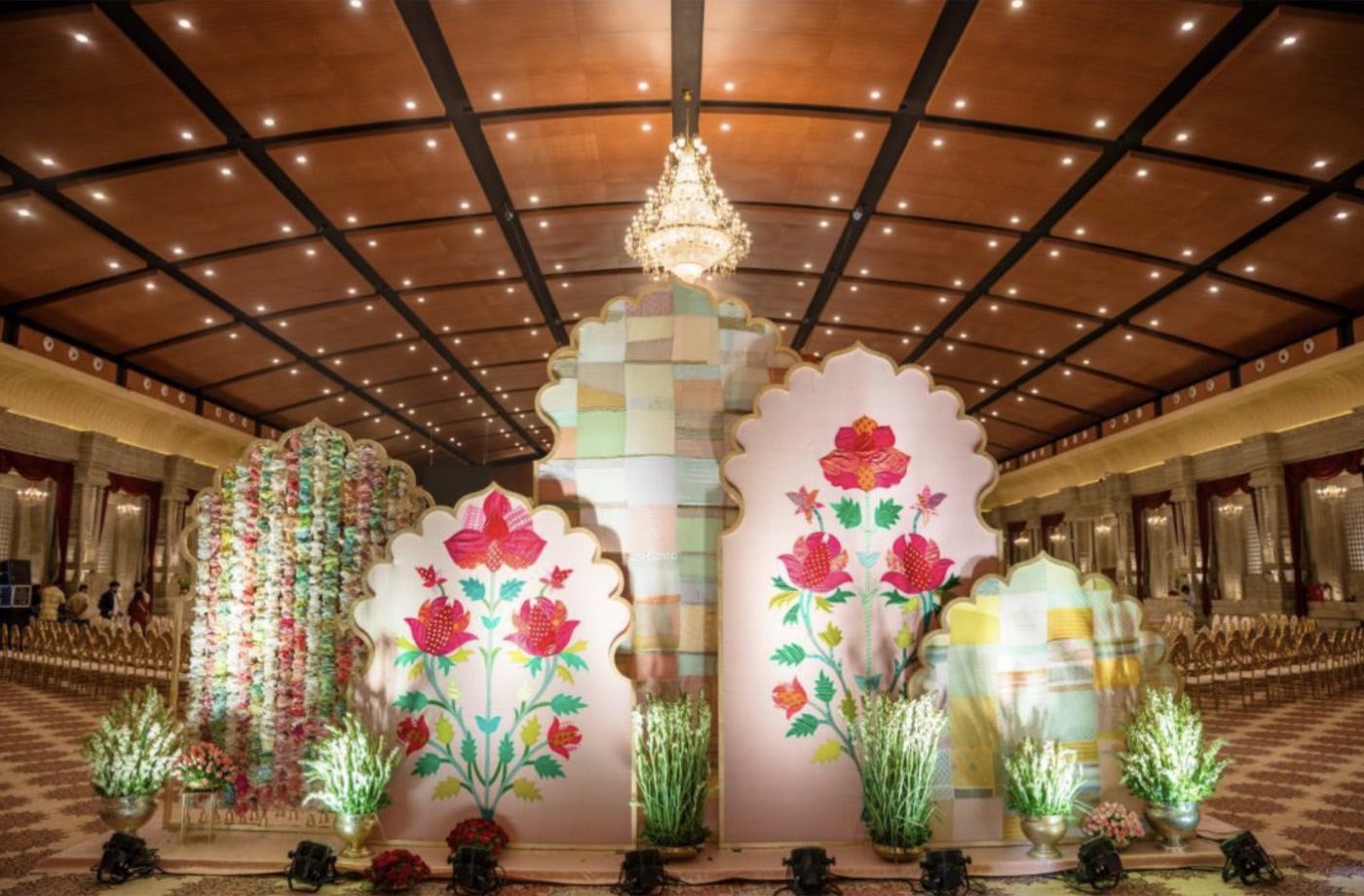 Scalloped panels with large fabric flower applique beside a garland strung from stitched fabric
