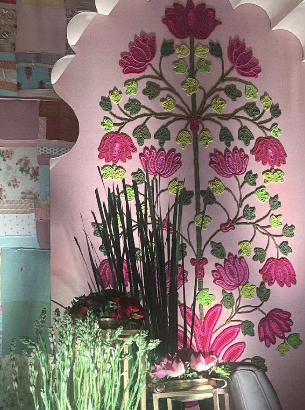 Detail of an appliqued lotus tree worked in cord and fabric across a pink panel