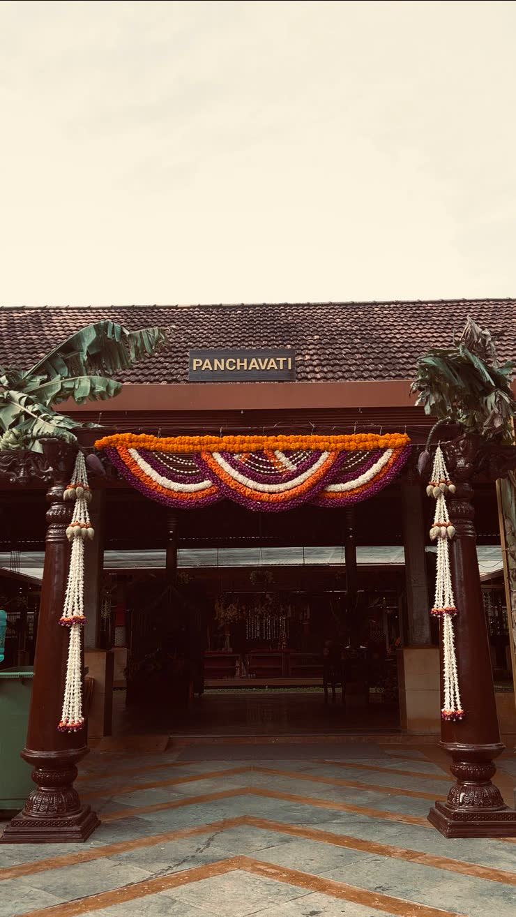 Entrance to Panchavati Pavilion dressed with a scalloped marigold, purple and white flower swag, jasmine ropes on the carved columns and fresh banana stems