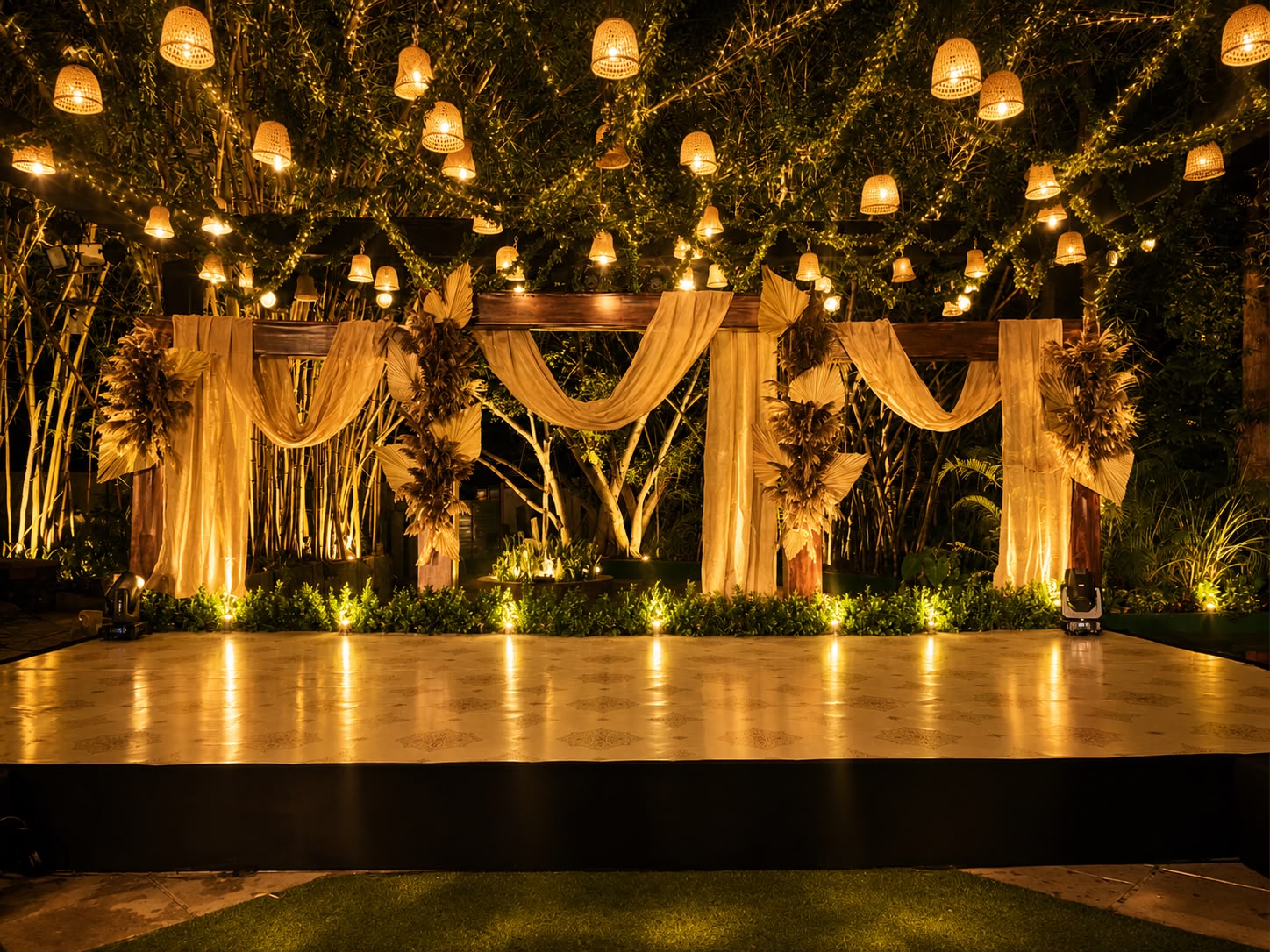 Cane lanterns hung into the tree canopy over a reception stage at MG Magnus Miraya Greens