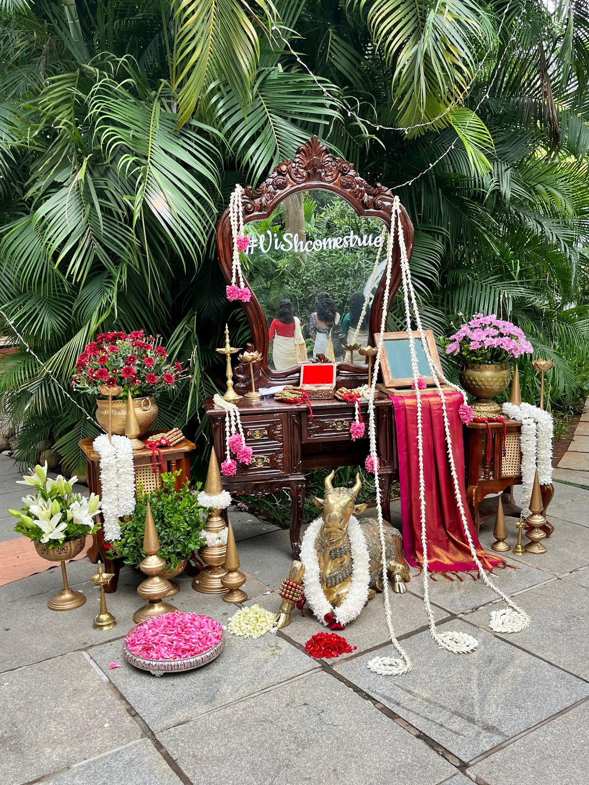 Vintage carved mirror vignette with garlanded brass Nandi, silk saree and brass lamps at a Tamil Brahmin wedding in Bangalore