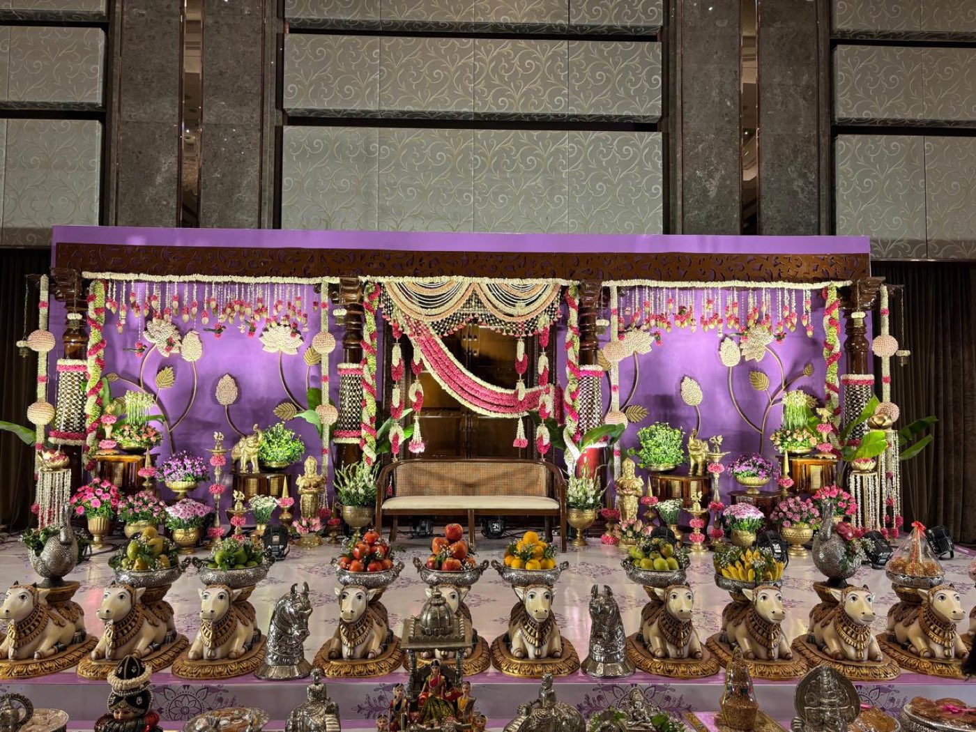 Half saree stage with a row of Nandi figures and silver thattu heaped with fruit across the foreground, Bangalore