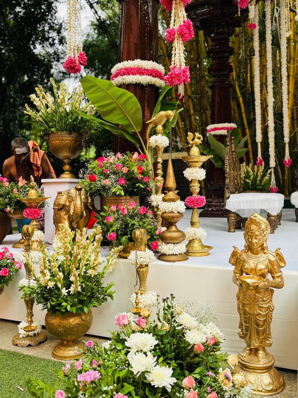 Brass annapakshi lamps, garlanded pillars and banana leaf beside the mandap stage at a South Indian wedding in Bangalore